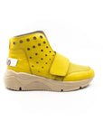 A yellow high-top sneaker with a velcro strap, metal eyelets, and a beige sole.