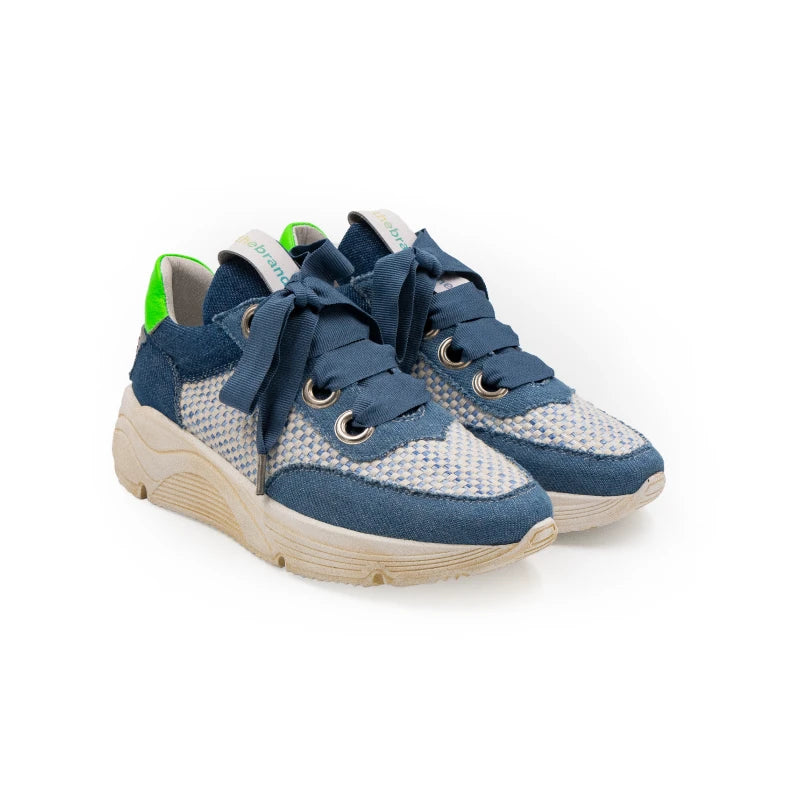 A stylish sneaker with blue leather and canvas upper, green accents, and a beige sole.