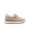 A beige sneaker with a Velcro strap and a low heel, suitable for casual wear.