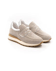 A beige sneaker with a Velcro strap and a low heel, suitable for casual wear.