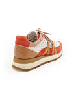 A women's sneaker with a beige, red, and white color scheme, featuring a lace-up closure and a flat sole.