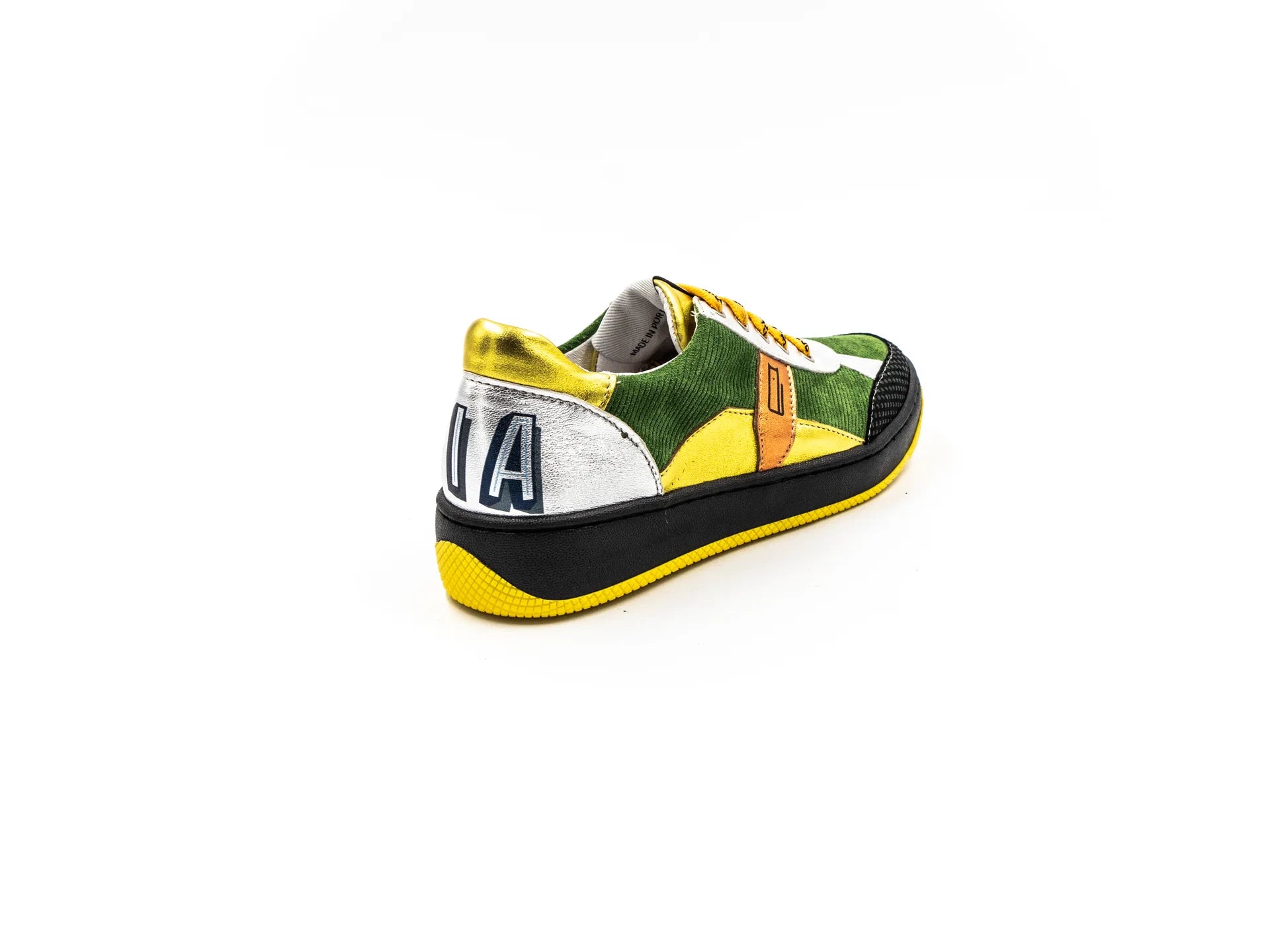 A sneaker with a mix of materials, featuring what appears to be a leather upper with a unique textured pattern, a white sole, and yellow laces.