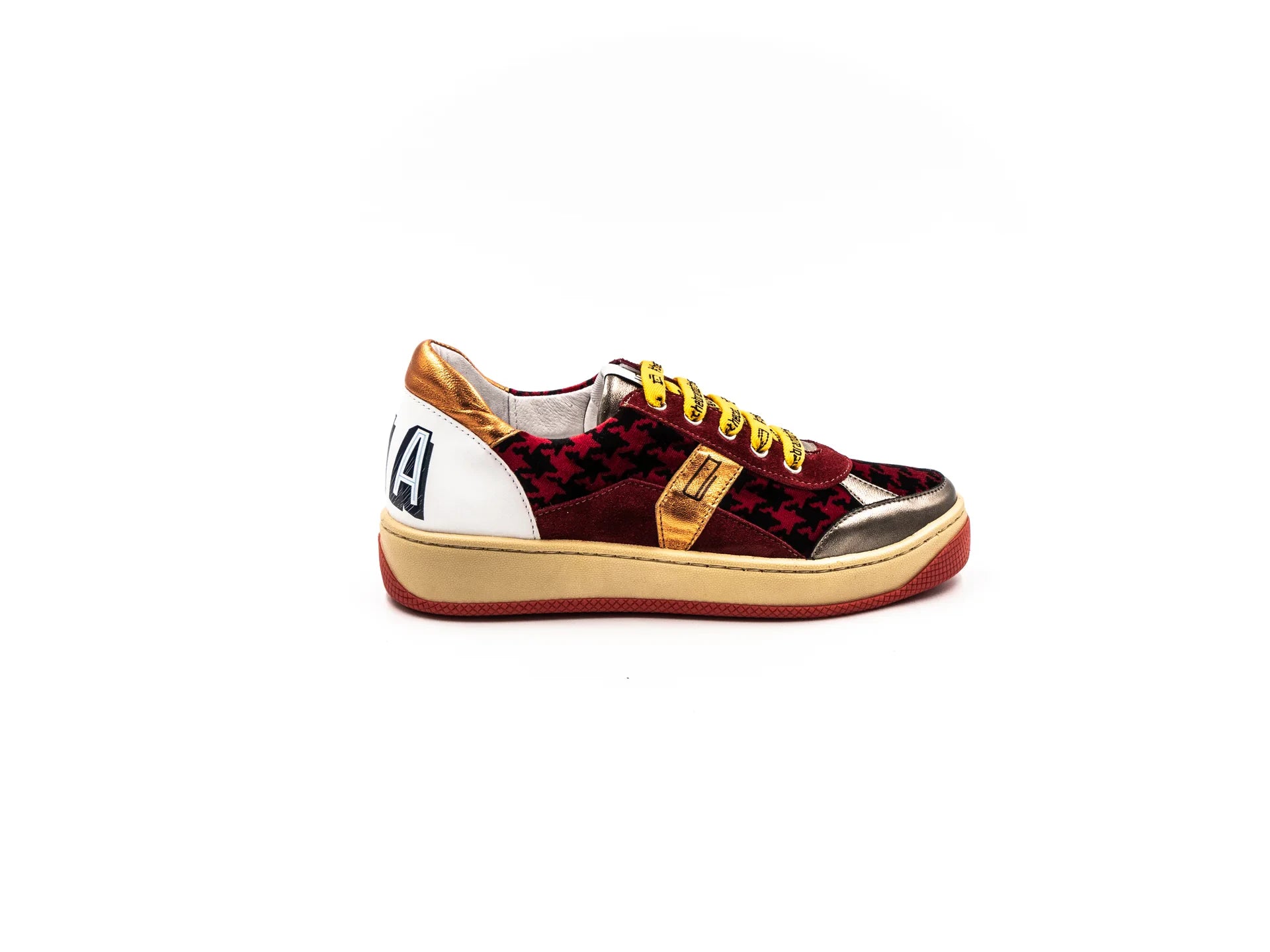 A sneaker with a mix of materials, featuring what appears to be a leather upper with a unique textured pattern, a white sole, and yellow laces.