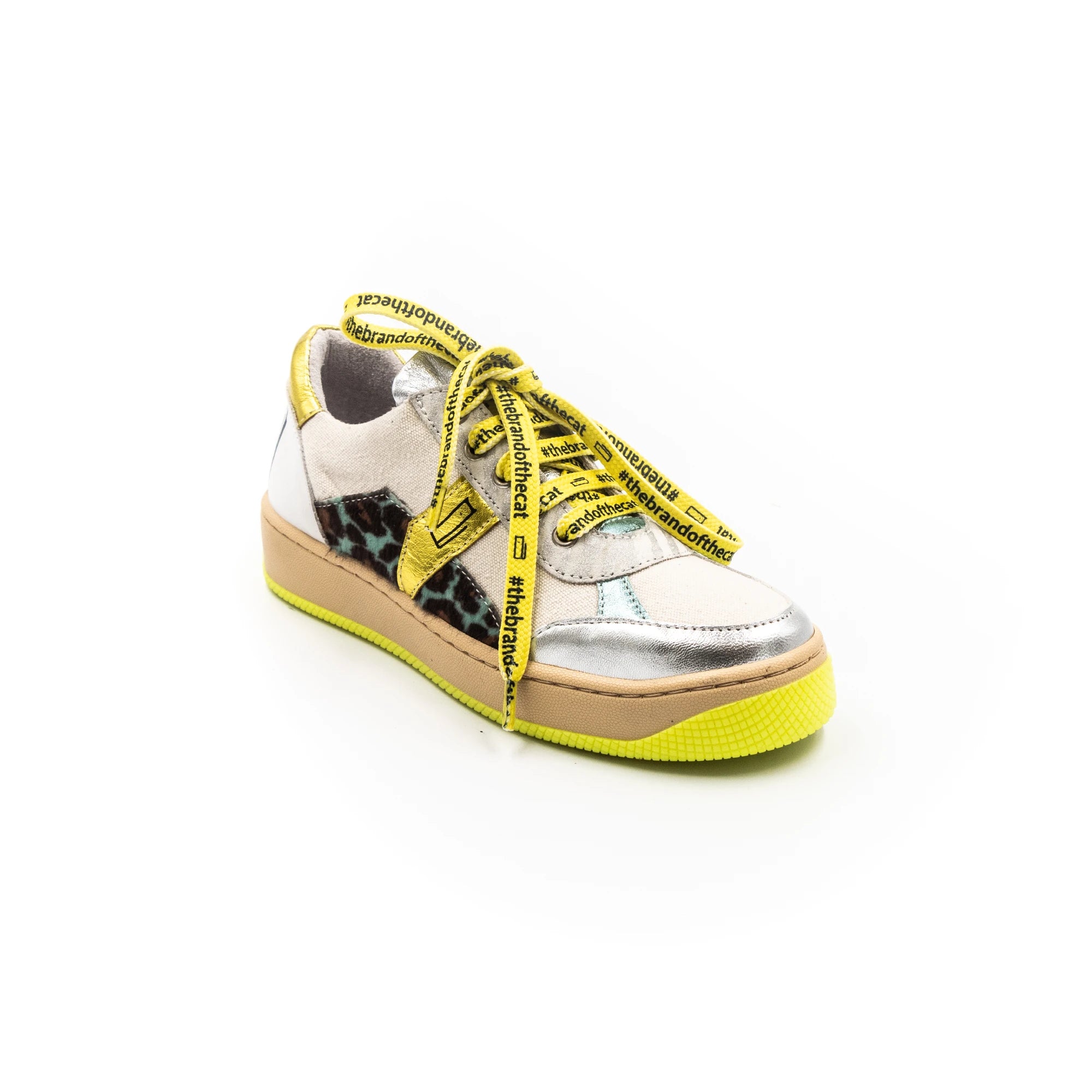 A sneaker with silver upper, yellow laces, and a beige sole.