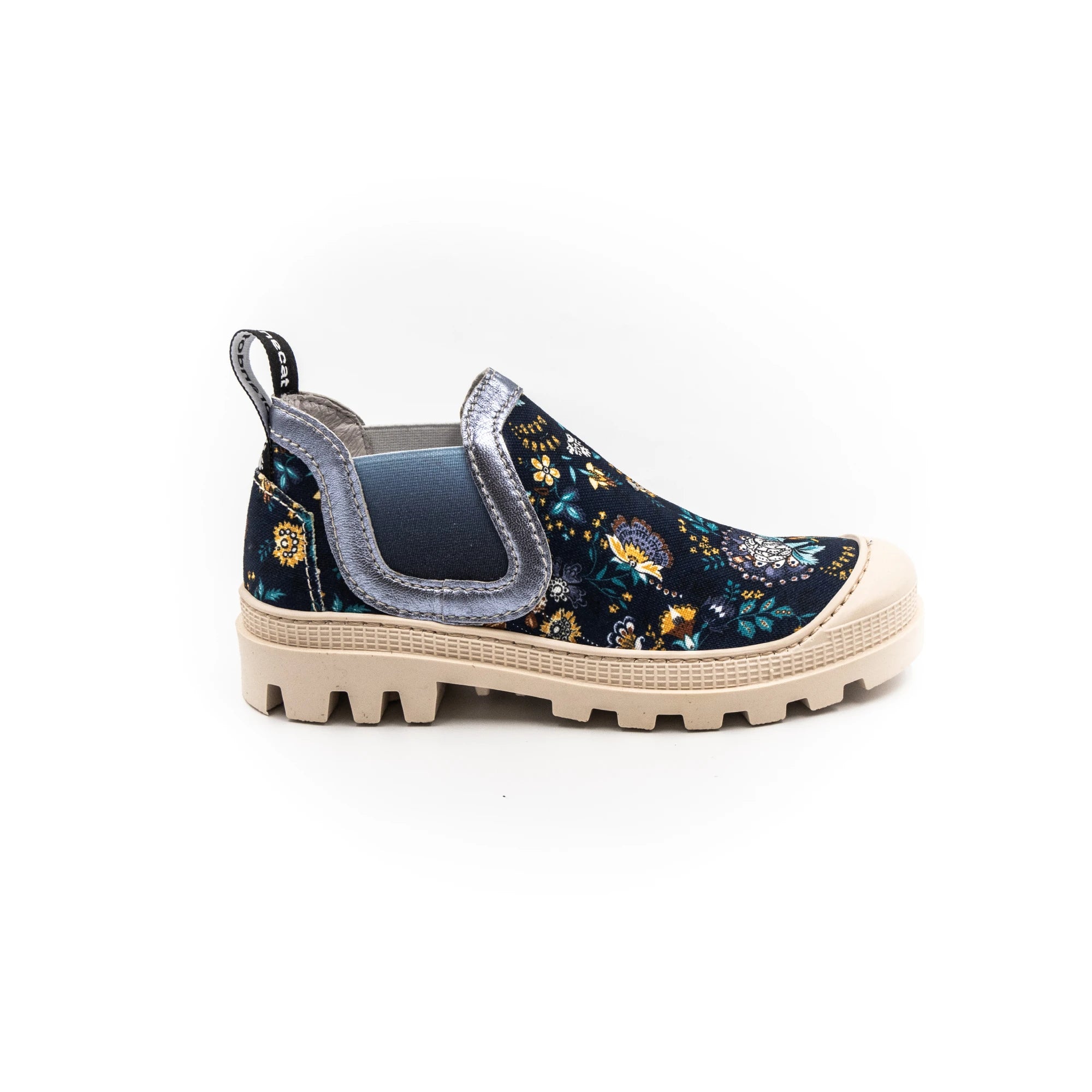 A sneaker with a multicolored floral print, featuring a round toe, a pull tab on the heel, and a flat sole.