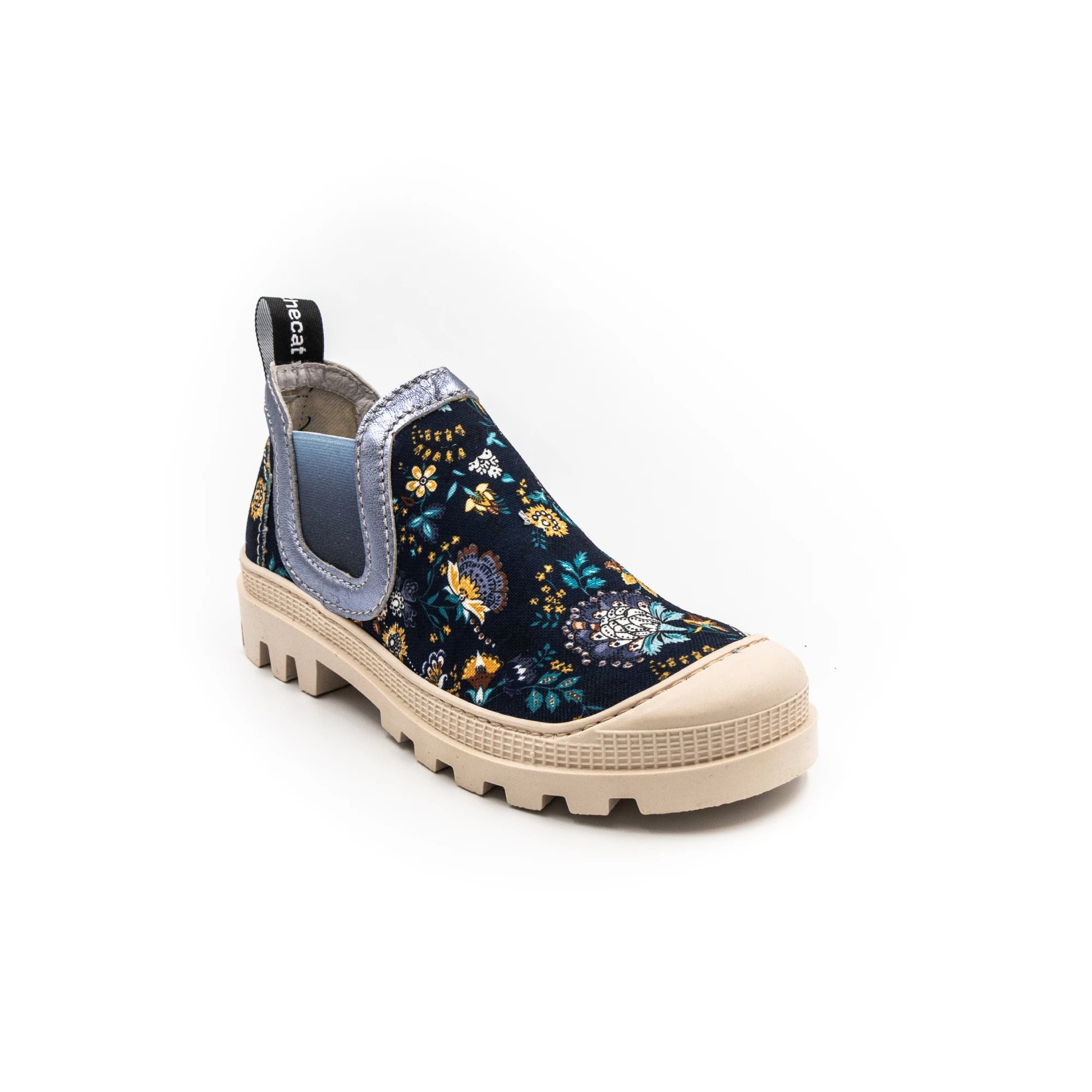 A sneaker with a multicolored floral print, featuring a round toe, a pull tab on the heel, and a flat sole.