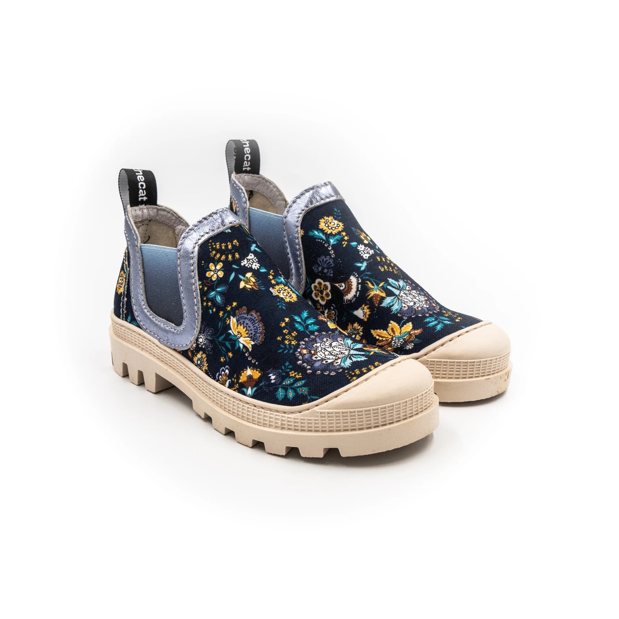 A sneaker with a multicolored floral print, featuring a round toe, a pull tab on the heel, and a flat sole.
