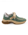 A green sneaker with beige accents and a brown sole, featuring a lace-up closure and a logo on the side.