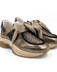 Pair of gold and black sneakers on a white background