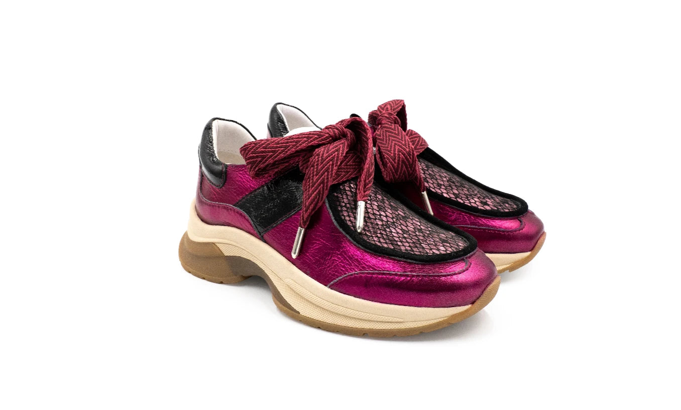 Pair of pink and black shoes with a bow on a white background