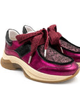 Pair of pink and black shoes with a bow on a white background