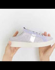 Purple sneakers with white lace and beige rubber. 